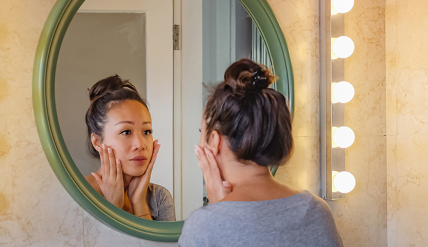 A woman looking at herself in the mirror