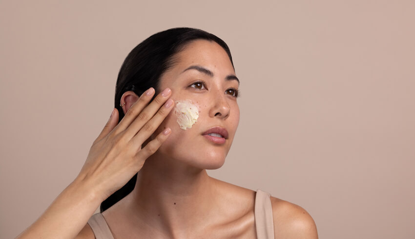 A woman applying skin care product