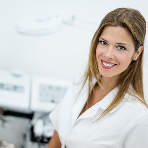 Female esthetician standing in front of various treatment machines.