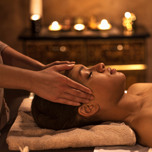 woman enjoying facial reflexology treatment