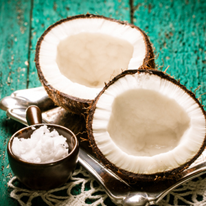 A container of coconut shavings sits besides a split coconut