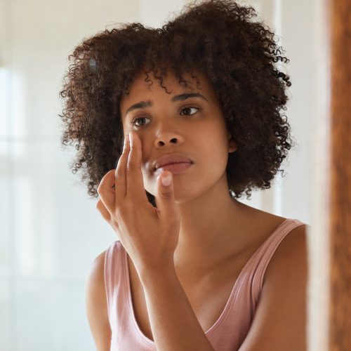 a woman applying moisturizer