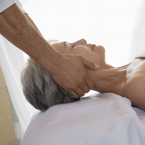 a mature woman receiving a neck massage