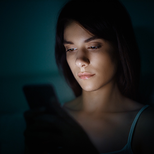 a woman looking at phone in bed