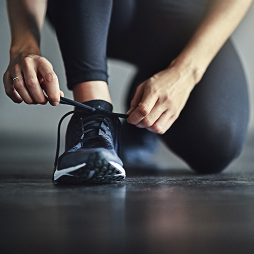 a woman tying running shoe