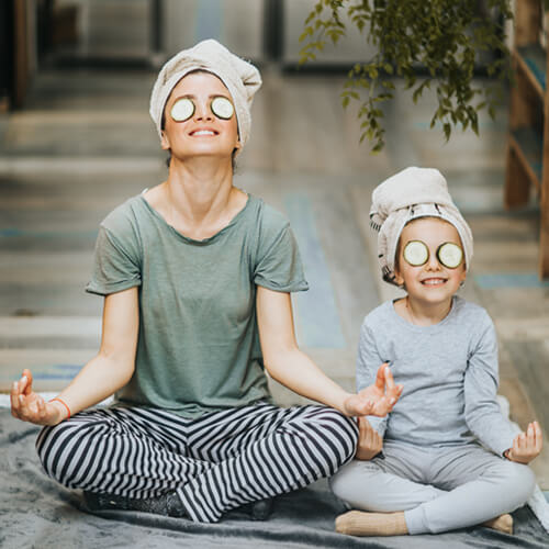 Mom and daughter meditating during an at home spa day