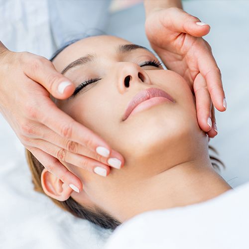 A woman receives a facial treatment at a spa.