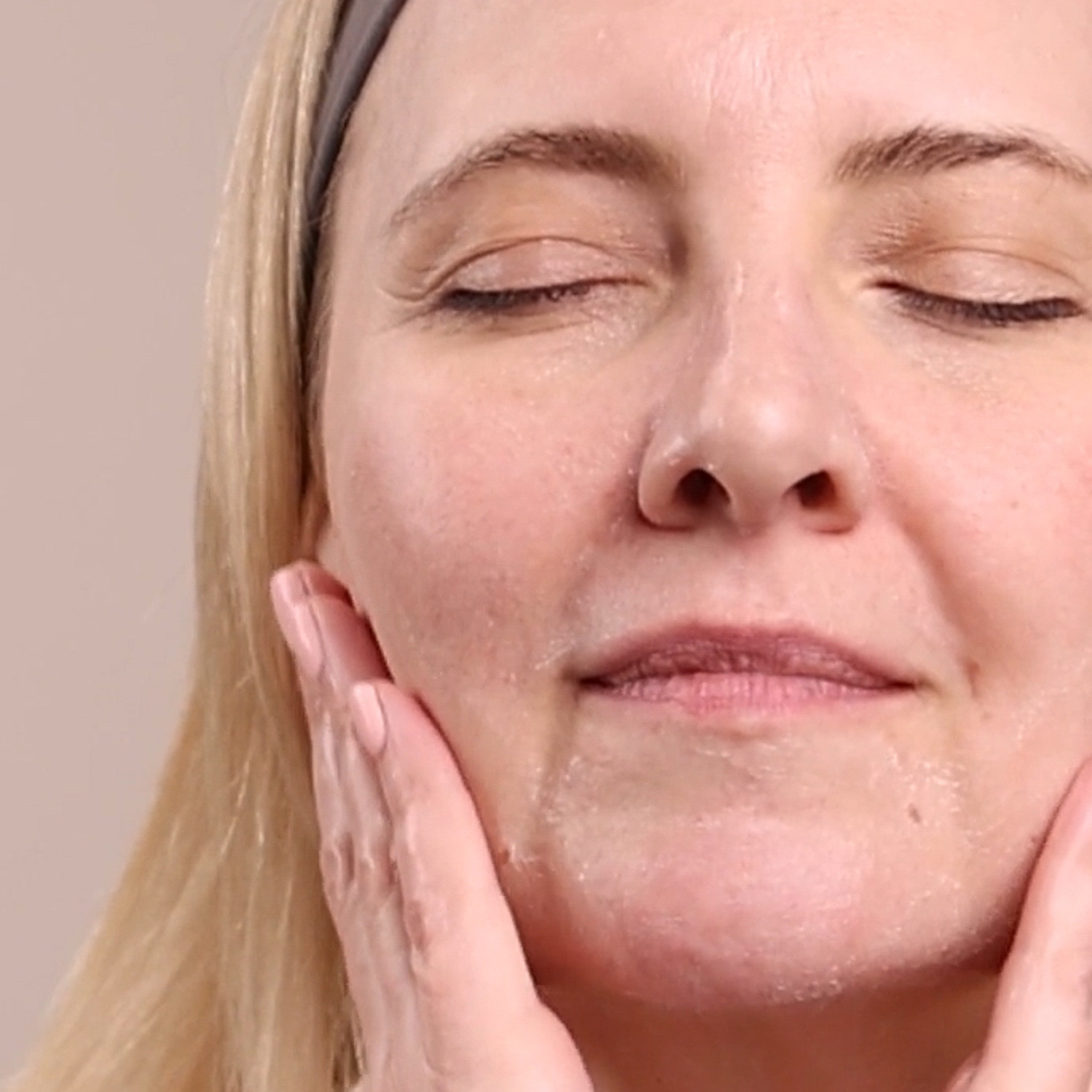 A woman applying the Eminence Organics Firm Skin Starter Set products to her face