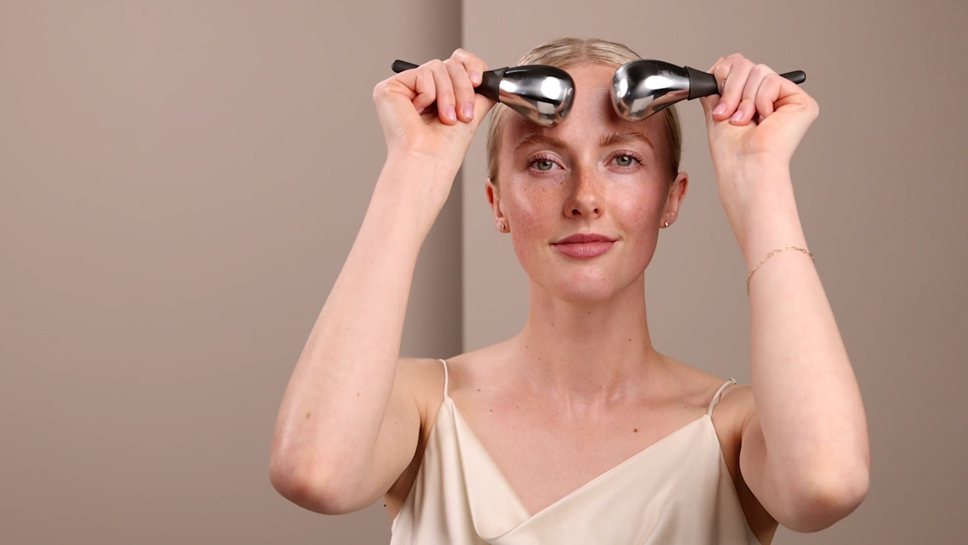 Eminence Organics Cryo-Thermal Sculpting Tool A woman using the Eminence Organics Cryo-Thermal Sculpting Tool on her face